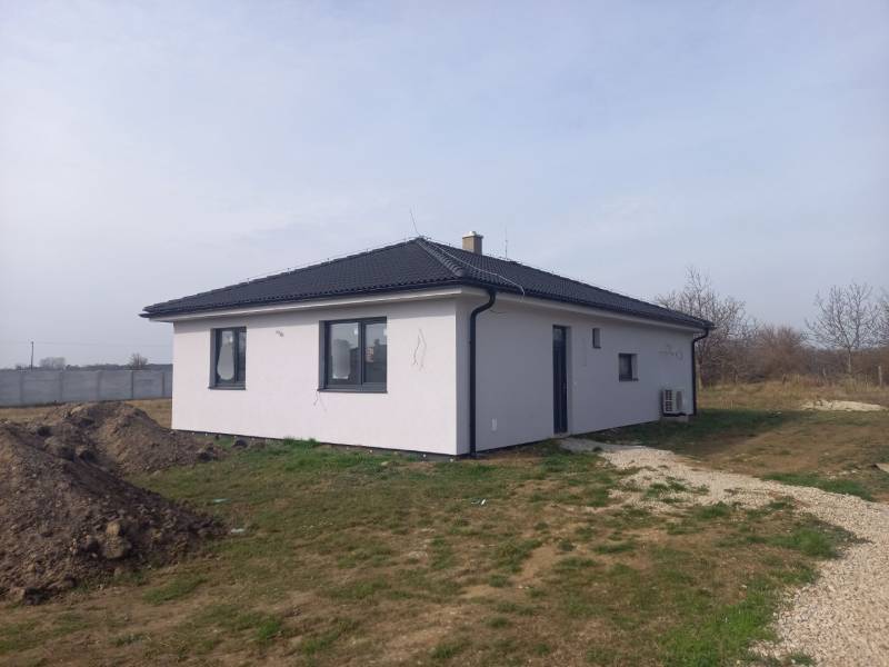 POSLEDNÁ Novostavba 4-izb rodinného domu v lukratívnej časti mesta - Rodinný dom v Galante s bielou fasádou stojí na trávnatom pozemku.