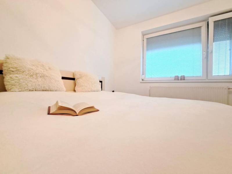 Miesto, kde sa budete cítiť doma–2-izbový byt na sídlisku West-Galana - Pohľad na posteľ s otvorenou knihou a oknom v 2-izbovom byte.