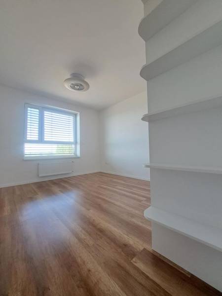 REZERVOVANÝ! Nová cena! Moderný 2-izbový byt – Galanta, sídlisko West - Izba v 2-izbovom byte s podlahou s dreveným dekorom, svetlými stenami a oknom.