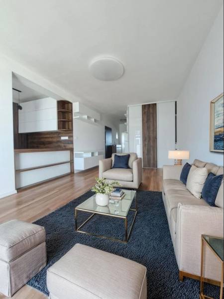 REZERVOVANÝ! Nová cena! Moderný 2-izbový byt – Galanta, sídlisko West - Obývacia izba v 2-izbovom byte s podlahou s dreveným dekorom a pohodlnými sedačkami.