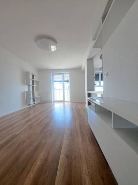 REZERVOVANÝ! Nová cena! Moderný 2-izbový byt – Galanta, sídlisko West - Obývací priestor v 2-izbovom byte s podlahou s dreveným dekorom a svetlými stenami.