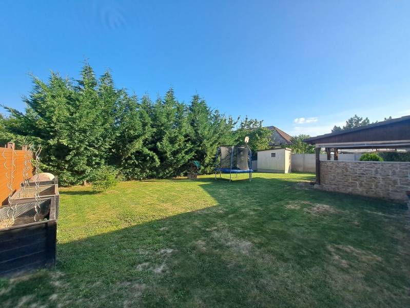 Predvianočná zľava! Na predaj krásny 4izb dom v obci Čierny Brod  - Záhrada rodinného domu v Čiernom Brode s trávnikom, trampolínou a hustými ihličnanmi.