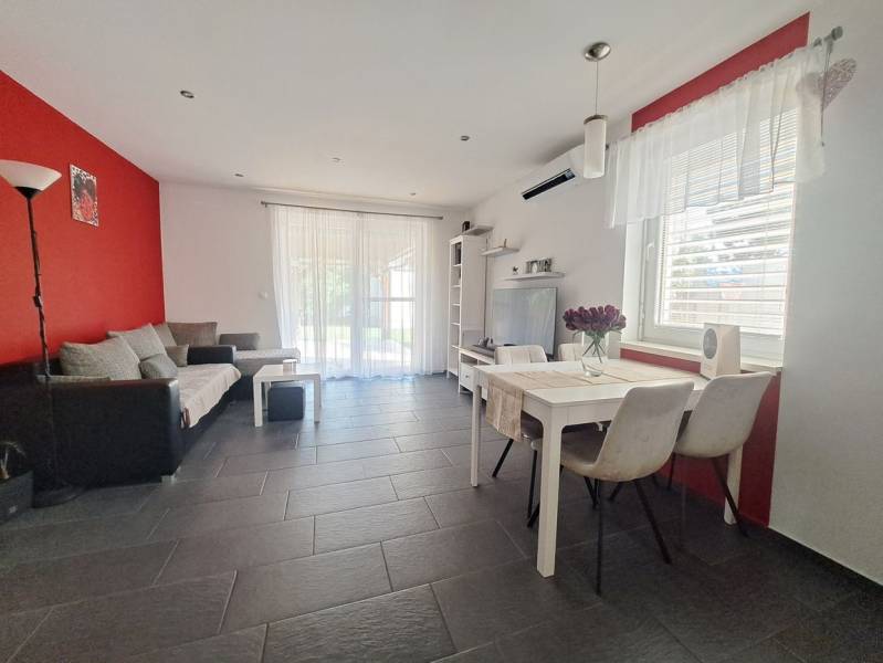 Predvianočná zľava! Na predaj krásny 4izb dom v obci Čierny Brod  - Obývačka v rodinnom dome s červenou stenou, sivou dlažbou a bielym nábytkom.