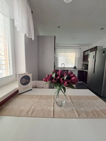 Predvianočná zľava! Na predaj krásny 4izb dom v obci Čierny Brod  - Kuchyňa v rodinnom dome s váhou tulipánov na stole a bielymi závesmi.