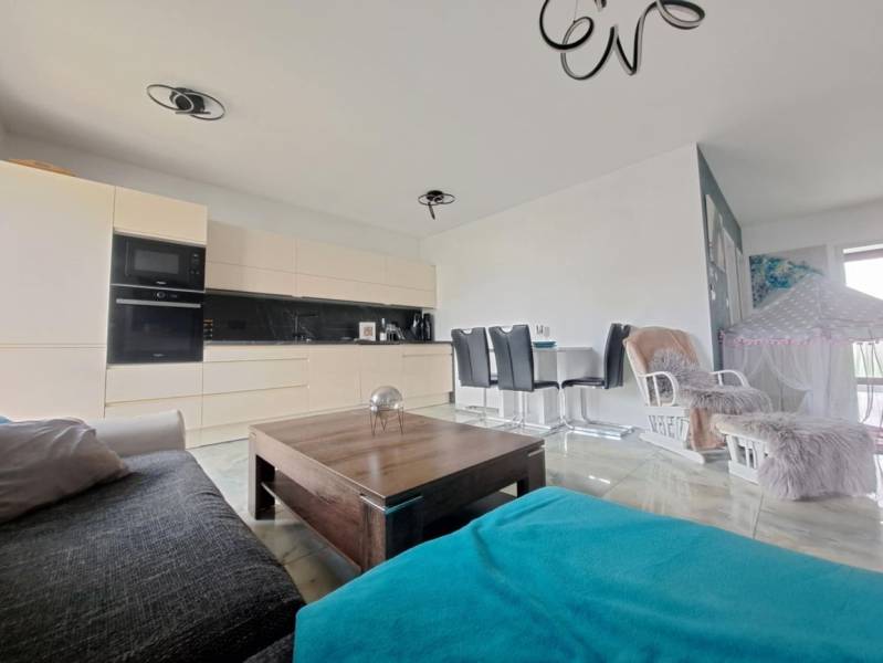 Neodolateľná ponuka! 4-izbová novostavba Galanta-Kolónia za super cenu - Obývačka v rodinnom dome s otvorenou kuchyňou a jedálenským stolom. Podlaha s dreveným dekorom.