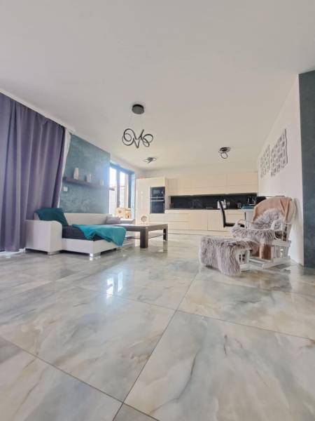 Neodolateľná ponuka! 4-izbová novostavba Galanta-Kolónia za super cenu - Obývacia izba s veľkými oknami a svetlými dlaždicami v rodinnom dome.