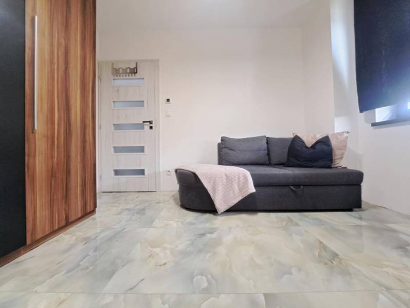 Neodolateľná ponuka! 4-izbová novostavba Galanta-Kolónia za super cenu - Izba v rodinnom dome s pohovkou, skrinkou, dverami a podlahou s mramorovým dekorom.