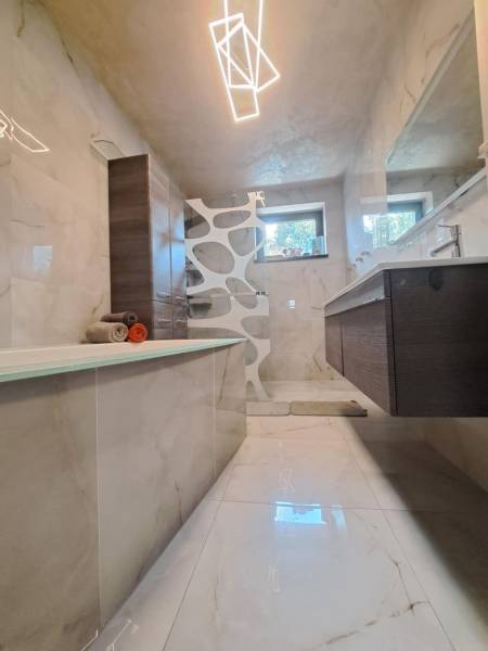 Neodolateľná ponuka! 4-izbová novostavba Galanta-Kolónia za super cenu - Kúpeľňa v rodinnom dome s vaňou, moderným osvetlením, dlažbou a umývadlom.