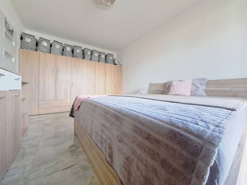 Neodolateľná ponuka! 4-izbová novostavba Galanta-Kolónia za super cenu - Spálňa v rodinnom dome s manželskou posteľou, skriňou a podlahou s dreveným dekorom.