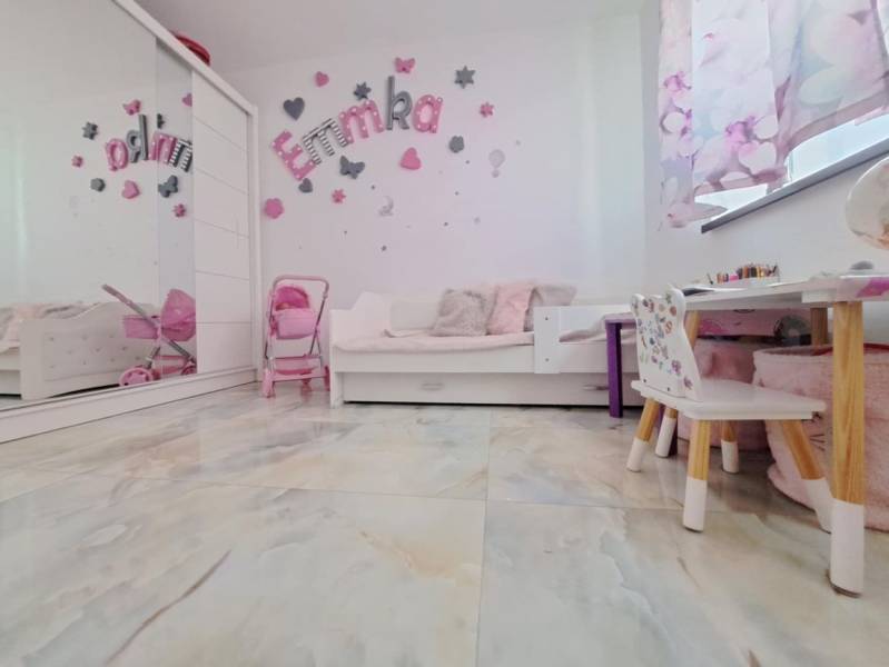 Neodolateľná ponuka! 4-izbová novostavba Galanta-Kolónia za super cenu - Detská izba v rodinnom dome s dekoráciami, nábytkom a hračkami, podlaha s dreveným dekorom.