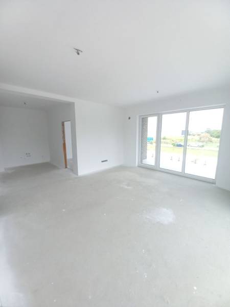 SKOLAUDOVANÉ! Novostavba 2-3 izbových bytov s pozemkom Richtárske pole - Svetlá obývacia izba v 2-izbovom byte s veľkými oknami a prázdnou podlahou.