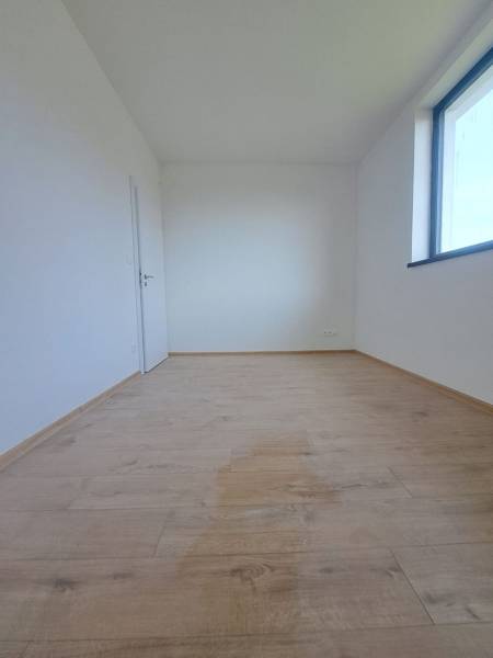 REZERVOVANÉ! Posledná novostavba 4-izbového dvojdomu v štandarde - Interiér rodinného domu so svetlou miestnosťou, podlaha s dreveným dekorom, veľké okno.