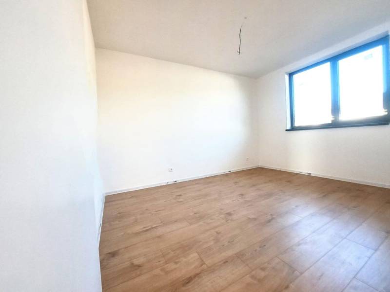 REZERVOVANÉ! Posledná novostavba 4-izbového dvojdomu v štandarde - Prázdna izba s podlahou s dreveným dekorom a veľkým oknom v rodinnom dome.