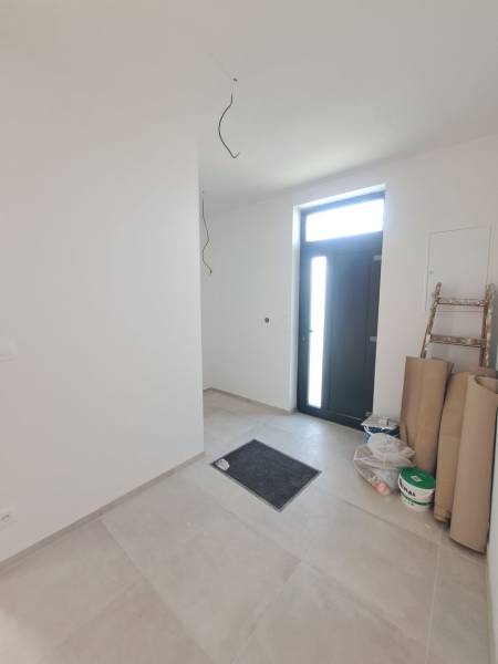 REZERVOVANÉ! Posledná novostavba 4-izbového dvojdomu v štandarde - Vstupná hala rodinného domu s dlažbou, vedľa dverí je schodík a materiál.