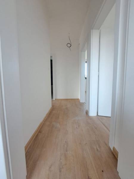 REZERVOVANÉ! Posledná novostavba 4-izbového dvojdomu v štandarde - Chodba s bielymi stenami a podlahou s dreveným dekorom v rodinnom dome.