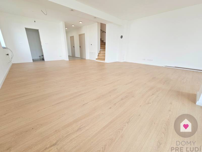 VEĽKORYSO RIEŠENÝ 4 izbový RD-128 m2 S TEP. ČERPADLOM, POZEMOK 405 m2 - Priestranná izba v rodinnom dome s podlahou s dreveným dekorom a schodiskom.