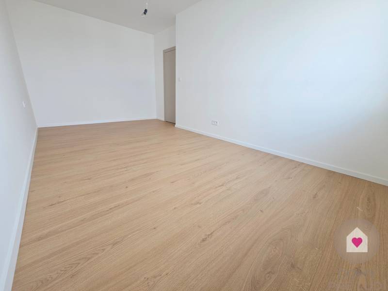 VEĽKORYSO RIEŠENÝ 4 izbový RD-128 m2 S TEP. ČERPADLOM, POZEMOK 405 m2 - Jasná prázdna izba v rodinnom dome s podlahou s dreveným dekorom.