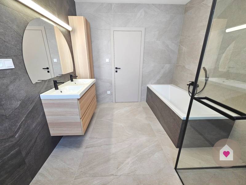 VEĽKORYSO RIEŠENÝ 4 izbový RD-128 m2 S TEP. ČERPADLOM, POZEMOK 405 m2 - Kúpeľňa s vaňou, dvojitým umývadlom a svetlými kachličkami v rodinnom dome.