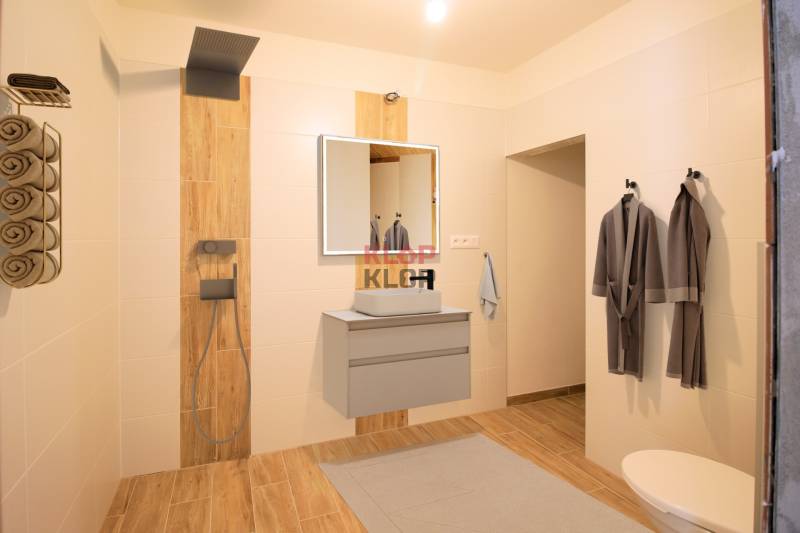 Kúpte si MODERNÚ NOVOSTAVBU 5i RD pri SENCI s MOŽNOSŤOU VÝMENY za BYT - Kúpeľňa v rodinnom dome s drevenou podlahou, sprchou a úložným priestorom na uteráky.