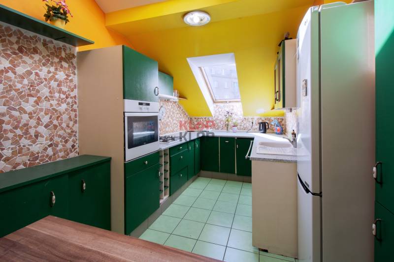 Kúpte si veľký PODKROVNÝ 4i BYT so ZÁHRADOU a PIVNICOU v Starom meste - Kuchyňa v 4-izbovom byte s farebnými skrinkami a strešným oknom.