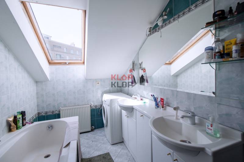 Kúpte si veľký PODKROVNÝ 4i BYT so ZÁHRADOU a PIVNICOU v Starom meste - Kúpeľňa v podkroví so strešnými oknami, vaňou, umývadlom a práčkou v 4-izbovom byte.