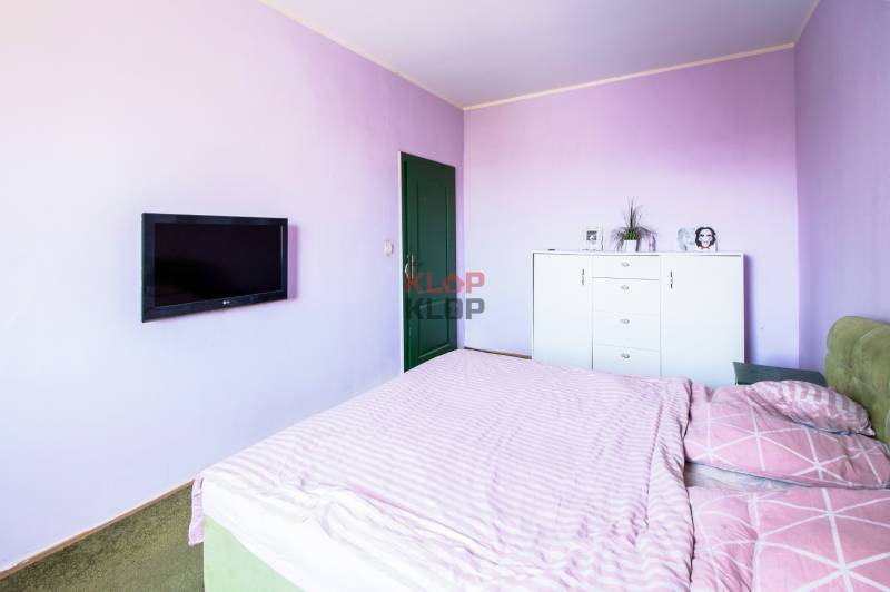 Kúpte si veľký PODKROVNÝ 4i BYT so ZÁHRADOU a PIVNICOU v Starom meste - Spálňa so svetloružovými stenami, posteľou a televízorom v 4-izbovom byte.