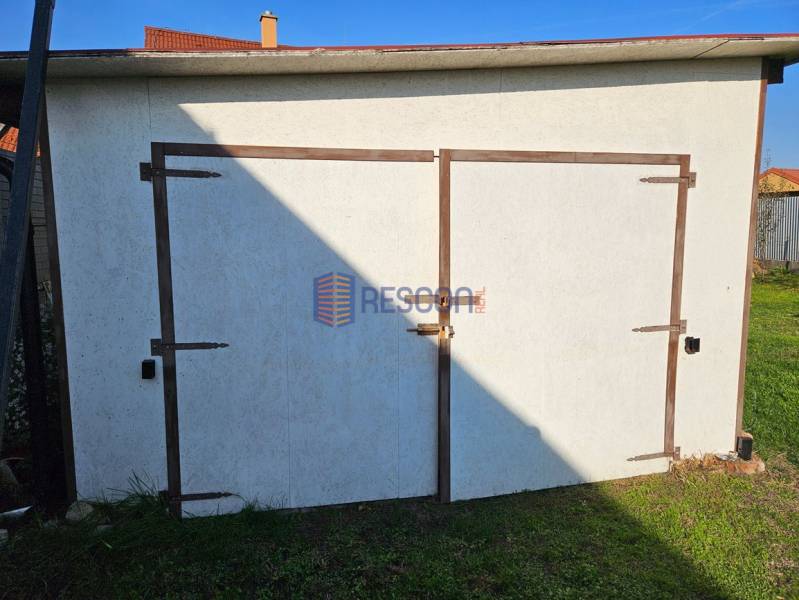 NOVÁ CENA !!  Atraktívny stavebný pozemok, obec Jakubov, 676 m - Biela garáž so zatvorenými drevenými dverami na pozemku v Jakubove, oblasť Pozemky - bývanie.