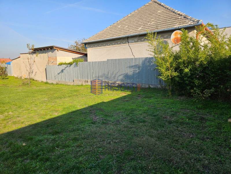 NOVÁ CENA !!  Atraktívny stavebný pozemok, obec Jakubov, 676 m - Trávnatý pozemok v Jakubove s vidieckym domom a plechovým plotom. Pozemky – bývanie.