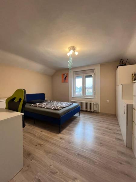 Dvojpodlažný 5i RD pri Dunajskej Strede, 55 min od BA - Spálňa v rodinnom dome s podlahou s dreveným dekorom, posteľou a pracovným stolom.