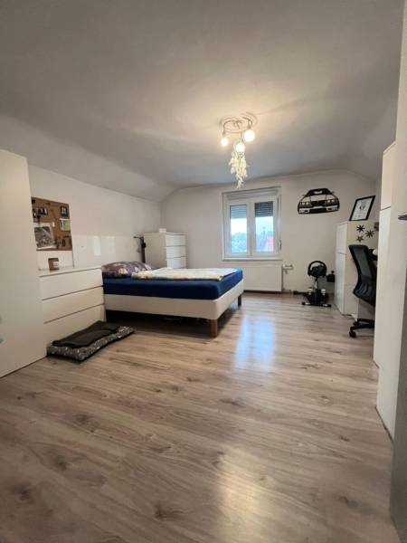 Dvojpodlažný 5i RD pri Dunajskej Strede, 55 min od BA - Spálňa v rodinnom dome s posteľou, bielym nábytkom a podlahou s dreveným dekorom.