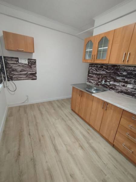  Na predaj  3i byt s vlastnou garážou neďaleko Šale - Kuchyňa v 3-izbovom byte má drevený dekor podlahy a jednoduché skrinky.