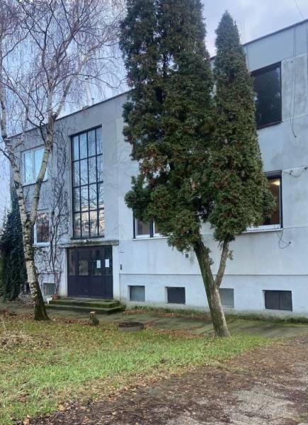  Na predaj  3i byt s vlastnou garážou neďaleko Šale - Exteriér budovy v Seliciach, obklopený stromami a trávnatým prostredím.