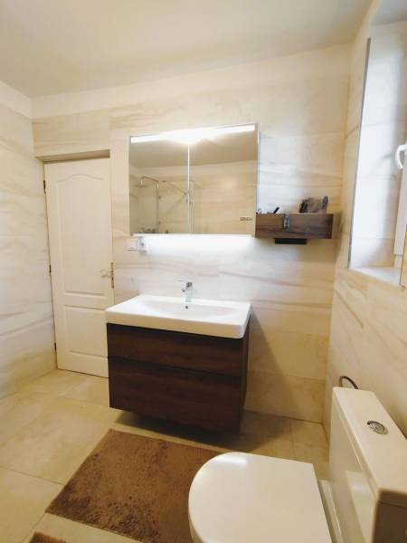 Predaj RD v Šali s bazénom - Kúpeľňa v rodinnom dome s bielymi stenami a umývadlom so zrkadlom.