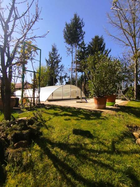 Predaj RD v Šali s bazénom - Bazén s prekrytím na záhrade rodinného domu v Šali, obklopený stromami a kríkmi.