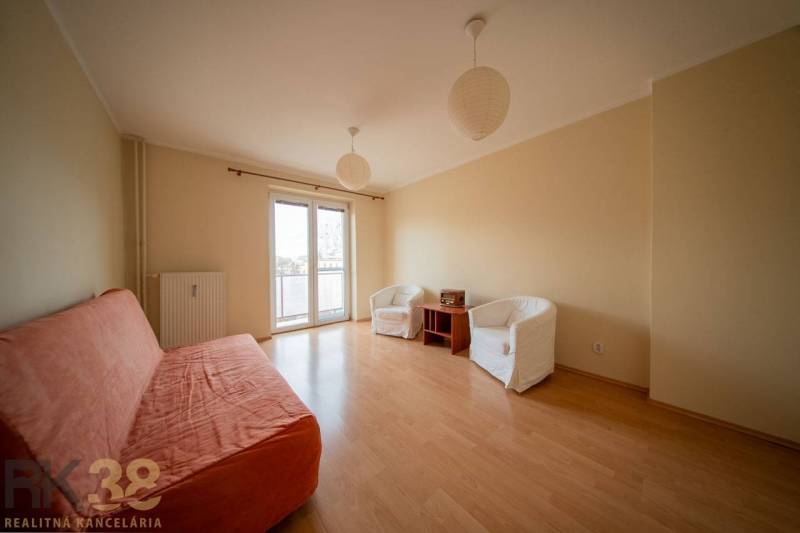 Rezervované: Na predaj pekný 2-izbový byt v centre mesta Poprad - Obývačka v 2-izbovom byte s podlahou s dreveným dekorom, pohovkou a kreslami.