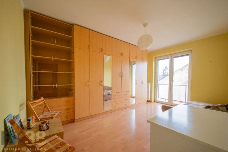 Rezervované: Na predaj pekný 2-izbový byt v centre mesta Poprad - Izba v 2-izbovom byte, s podlahou s dreveným dekorom a nábytkom v prírodných odtieňoch.