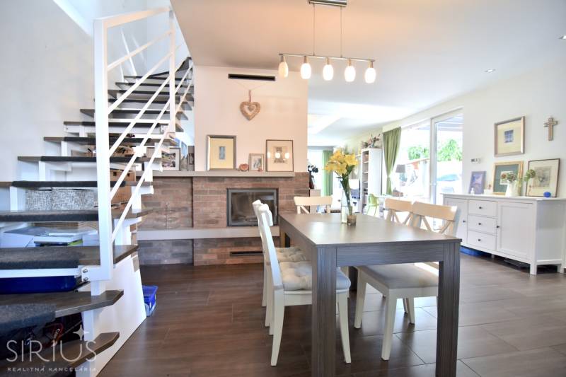 HROZNOVÁ, 4-i RD, 161 m2 – novostavba, krb, klíma, krásna záhrada - Jedáleň v rodinnom dome s krbom, schodiskom a podlahou s dreveným dekorom.