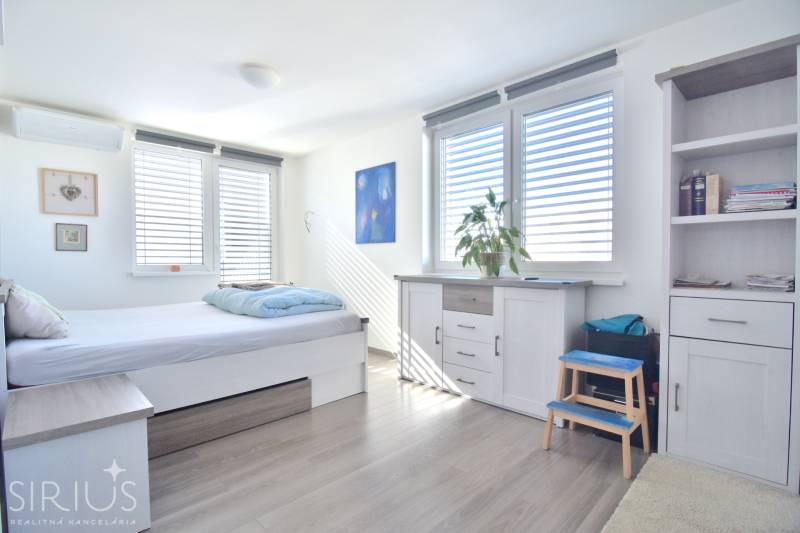 HROZNOVÁ, 4-i RD, 161 m2 – novostavba, krb, klíma, krásna záhrada - Svetlá izba s posteľou, komodou a bielymi skrinkami v rodinnom dome.