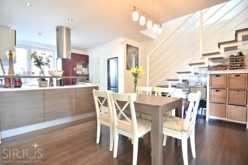 HROZNOVÁ, 4-i RD, 161 m2 – novostavba, krb, klíma, krásna záhrada - Jedáleň v rodinnom dome s podlahou s dreveným dekorom, schodiskom a kuchynským kútom.