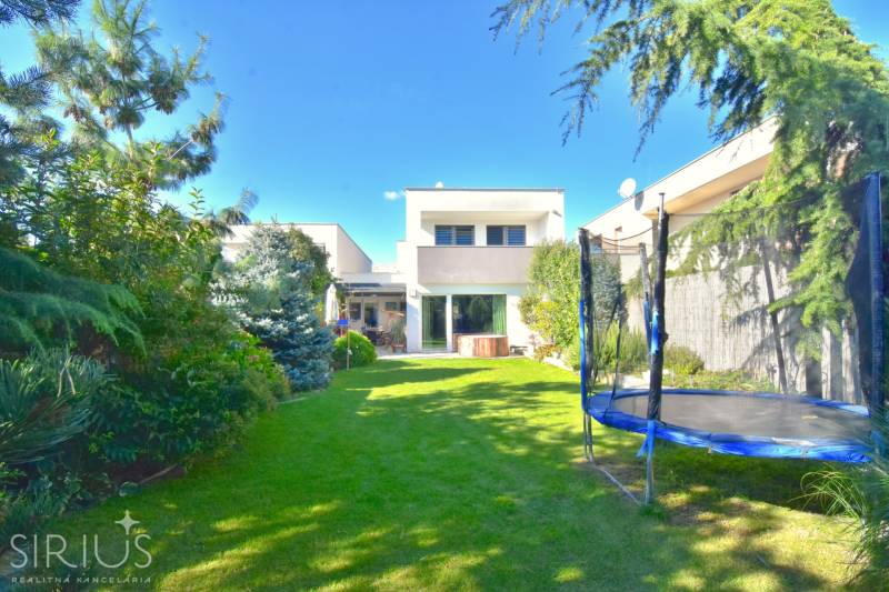 HROZNOVÁ, 4-i RD, 161 m2 – novostavba, krb, klíma, krásna záhrada - Záhrada rodinného domu na Hroznovej ulici v Ivanke pri Dunaji, s trampolínou a zeleňou.