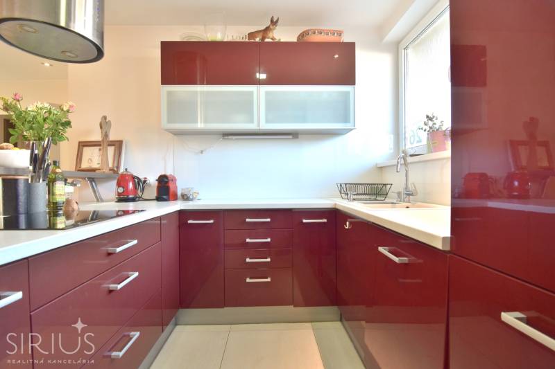 HROZNOVÁ, 4-i RD, 161 m2 – novostavba, krb, klíma, krásna záhrada - Kuchyňa v rodinnom dome s vínovo červenými skrinkami a moderným vybavením.