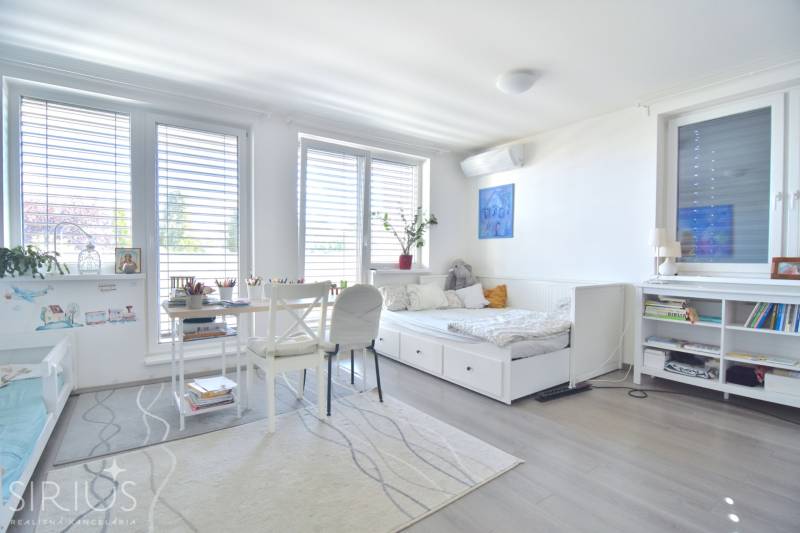 HROZNOVÁ, 4-i RD, 161 m2 – novostavba, krb, klíma, krásna záhrada - Detská izba v rodinnom dome s podlahou s dreveným dekorom, posteľou a stolom na kreslenie.