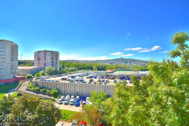 BAKOŠOVA, 1-i byt, 43 m2 – nerušený VÝHĽAD NA KARPATY - Výhľad na parkovisko a okolie v Bratislave - Lamači z Bakošovej, zachytávajúci zeleň a budovy.