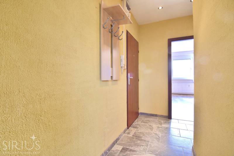 BAKOŠOVA, 1-i byt, 43 m2 – nerušený VÝHĽAD NA KARPATY - Chodba so žltými stenami a vešiakom, vedúca k miestnosti v 1-izbovom byte.