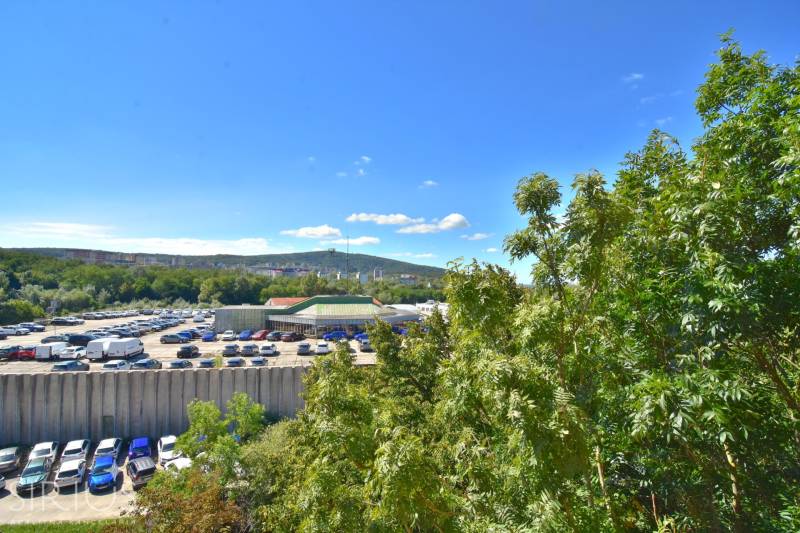 BAKOŠOVA, 1-i byt, 43 m2 – nerušený VÝHĽAD NA KARPATY - Parkovisko s autami a zeleňou pri Bakošovej ulici v Bratislave - Lamači.