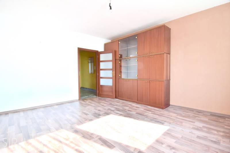 BAKOŠOVA, 1-i byt, 43 m2 – nerušený VÝHĽAD NA KARPATY - Izba s dreveným dekorom podlahy a nábytkovou stenou v 1-izbovom byte.