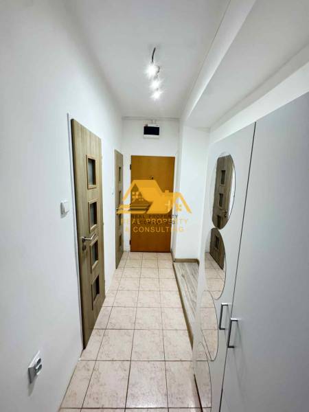 Prenajmem 3 izbový byt s balkónom v Nových Zámkoch - Chodba s bielymi stenami, dlažbou a drevenými dverami v 3-izbovom byte.