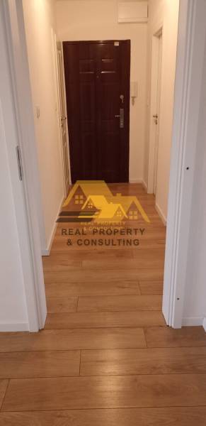 Prerobený 2 izbový byt s balkónom v Nových Zámkoch - Úzka chodba so vstupnými dverami a podlahou s dreveným dekorom v 2-izbovom byte.