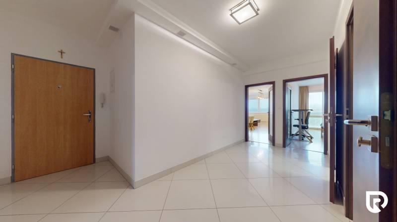 | Svetlý priestranný 2 izbový byt | parkovanie | REZERVOVANÝ - Vstupná chodba v 2-izbovom byte s bielymi stenami a keramickou dlažbou.