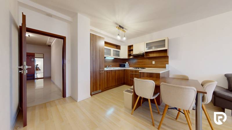 | Svetlý priestranný 2 izbový byt | parkovanie | REZERVOVANÝ - Kuchyňa v 2-izbovom byte s podlahou s dreveným dekorom, zariadená kuchynská linka.